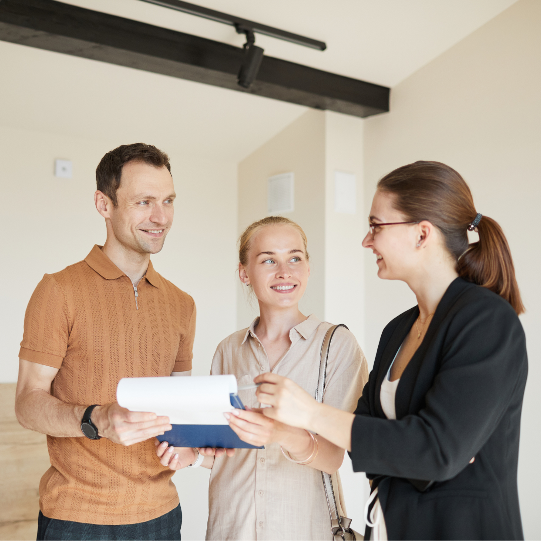 property-management-portland (3) a rental agent and two people in an empty apartment, signing papers