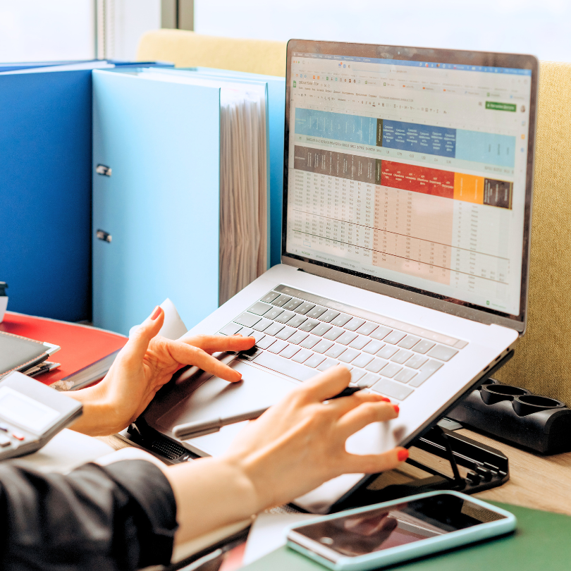 Woman on a laptop with spreadsheet software open.